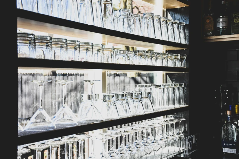 a shelf full of many different kinds of glasses