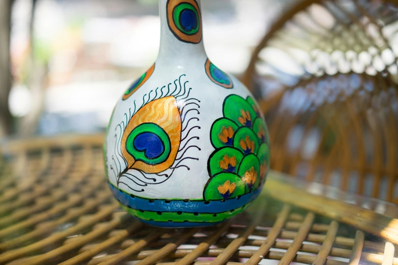 a decorated vase sitting on top of a wicker table