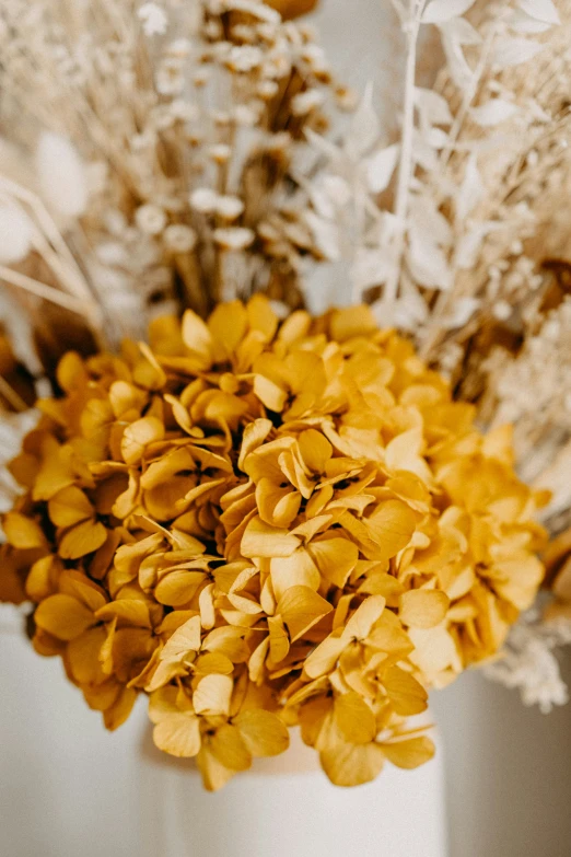 yellow flowers in a vase sitting on a table