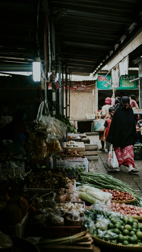 many people walk near produce at an outdoor market