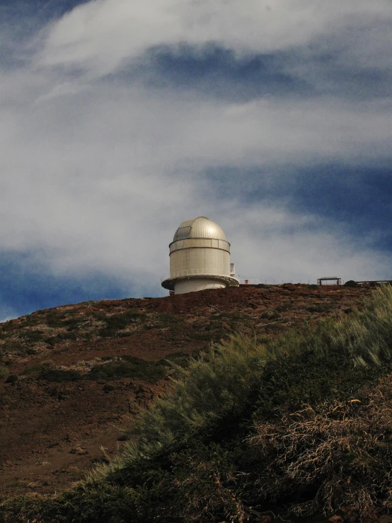 an old telescope set on the top of a hill