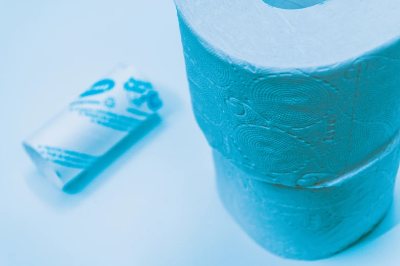 a roll of toilet paper and a blue tube on a table