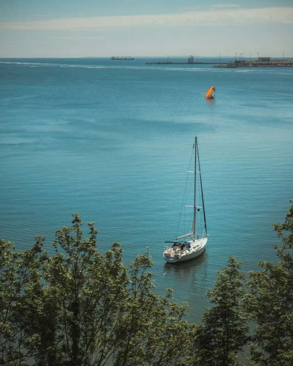 an old fashioned sailboat floating in the ocean on a clear day