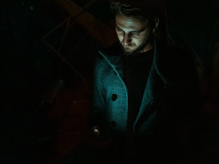 a man wearing a jacket at night using his laptop