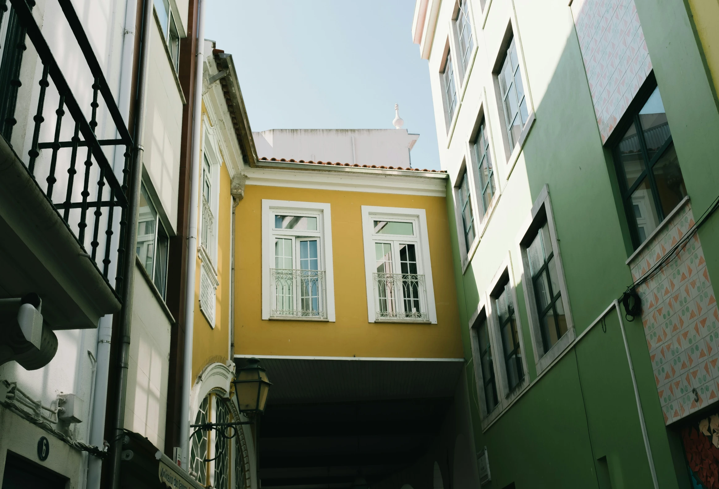 several buildings in a narrow alley with windows