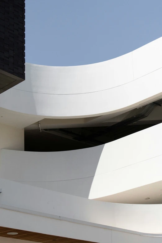 looking up at a futuristic architecture that resembles a sheet of white paint