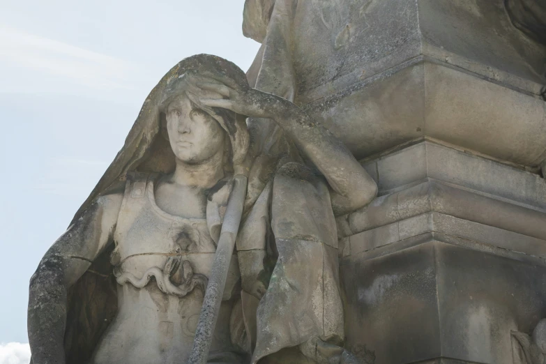 the statue of an angel holding the hand and touching it's head