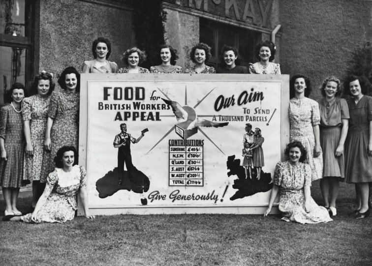 an old black and white po shows a group of women standing in front of a big banner