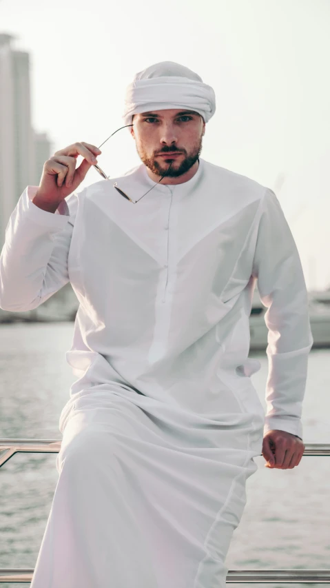 man wearing white clothes sits on the boat