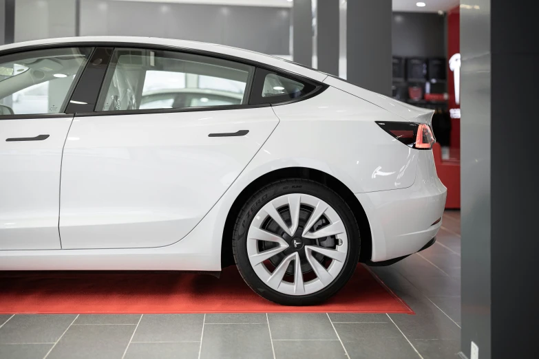 a white electric car is parked in a building