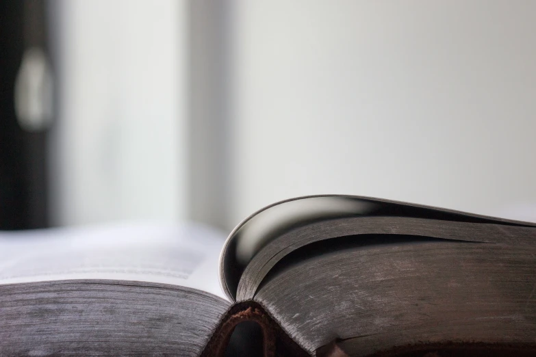 an open book lying on top of a white surface