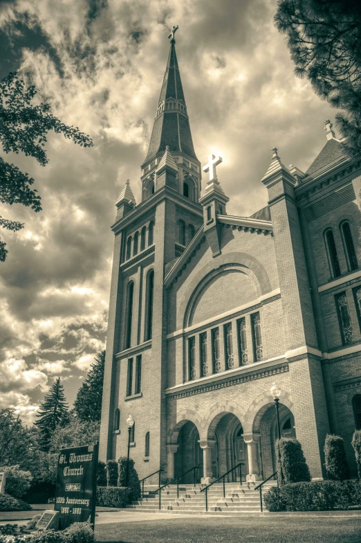 large old cathedral with a clock tower and cross