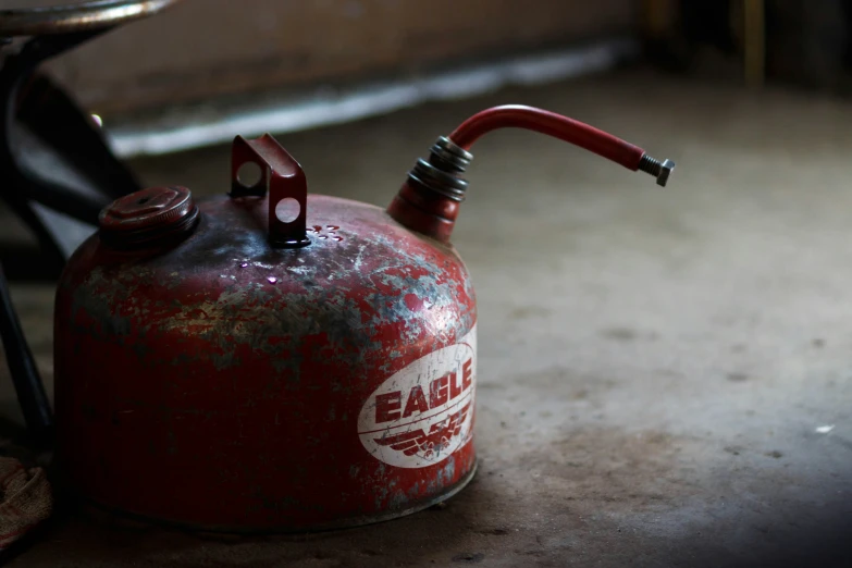 an old red fire extinguisher with a spout
