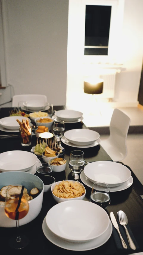 a large black table set with plates and bowls and plates