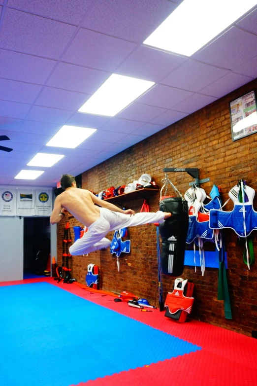 the person in white trunks is jumping over a wrestling mat