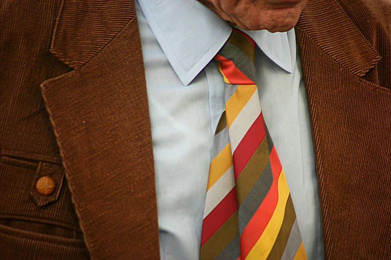 an old man wearing a suit with a colorful striped tie