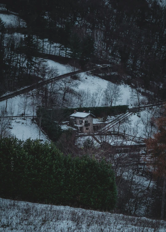 snow covered trees and a white house surrounded by woods