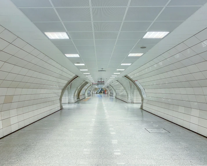 a very long white subway tunnel with an artistic design