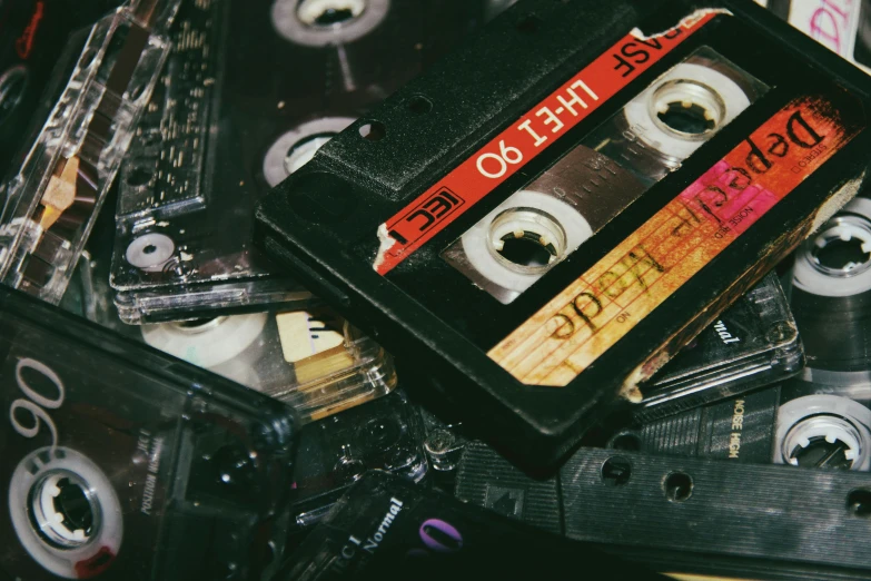 various old tapes and cassettes stacked up on top of each other