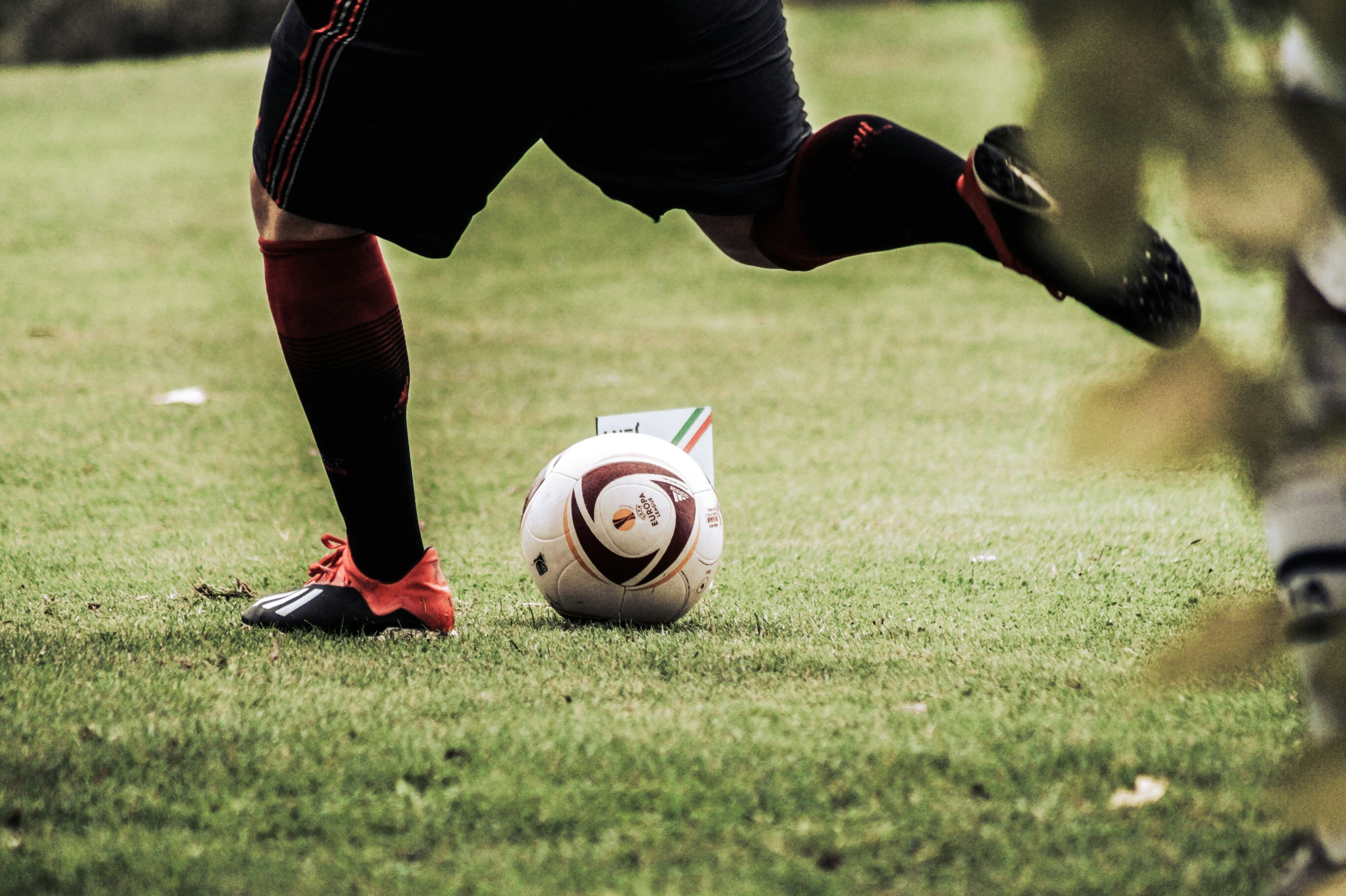 a soccer player getting ready to kick a ball on a field