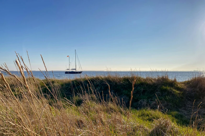 a sailboat out in the open water near sand