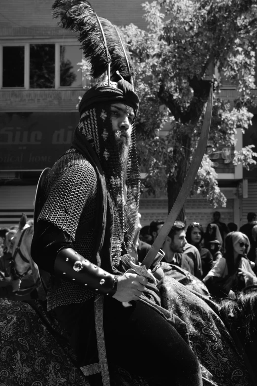 a man sitting down holding a sword and a stick