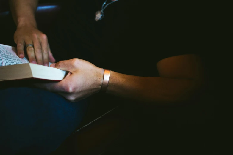 the person is holding a book in his hand