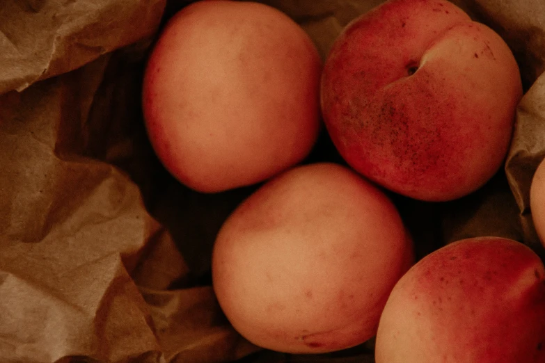 five apples and one pear in brown paper bag