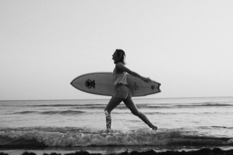 a woman with a surfboard standing in the water