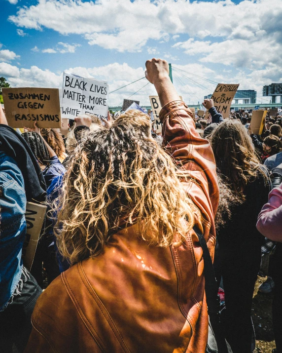 a group of people at an rally that are holding signs