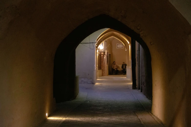 an arch in a building lit by street lamps