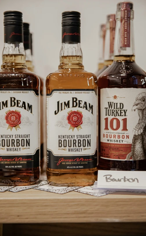 three bottles of bourbon are sitting on a shelf