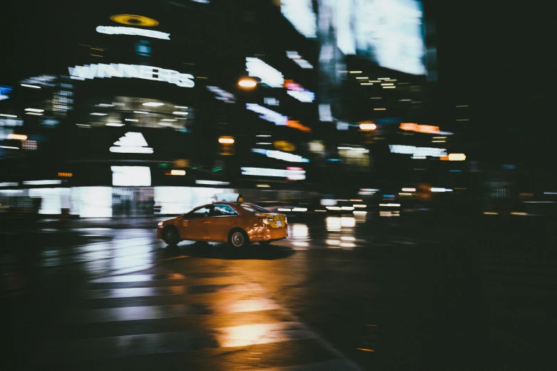 car on the road during rainy night with lights and buildings