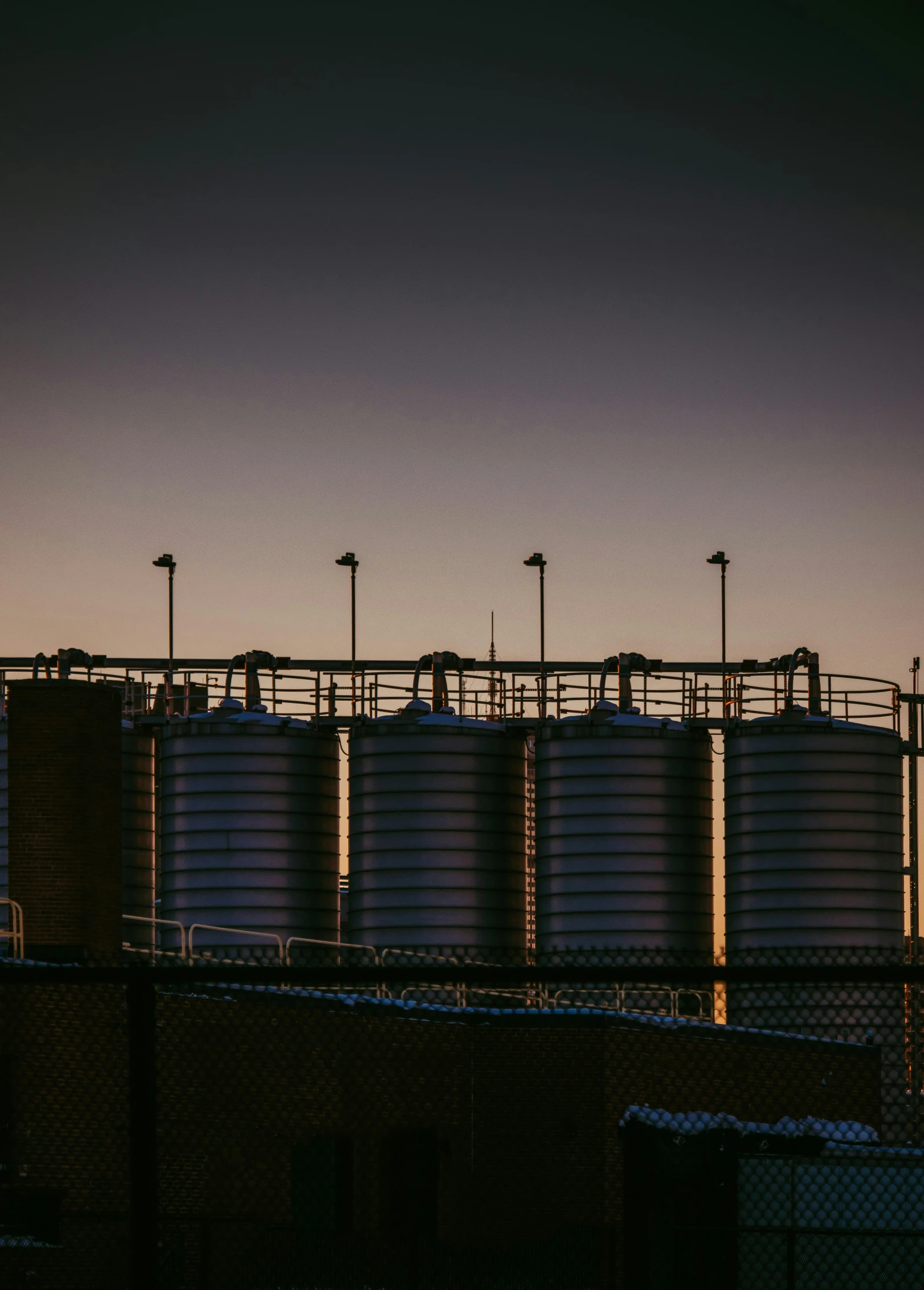 silhouette of grain silos in background with dusk sky