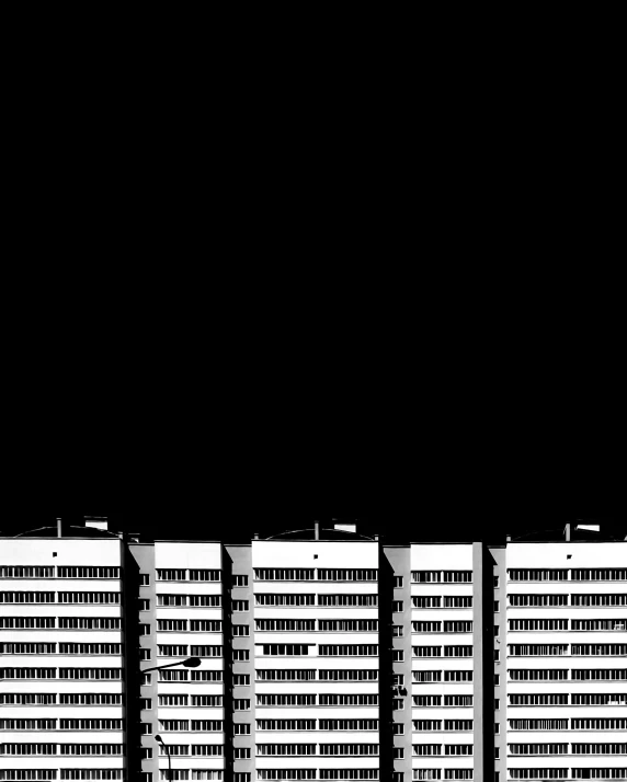a line of tall white buildings on a dark background
