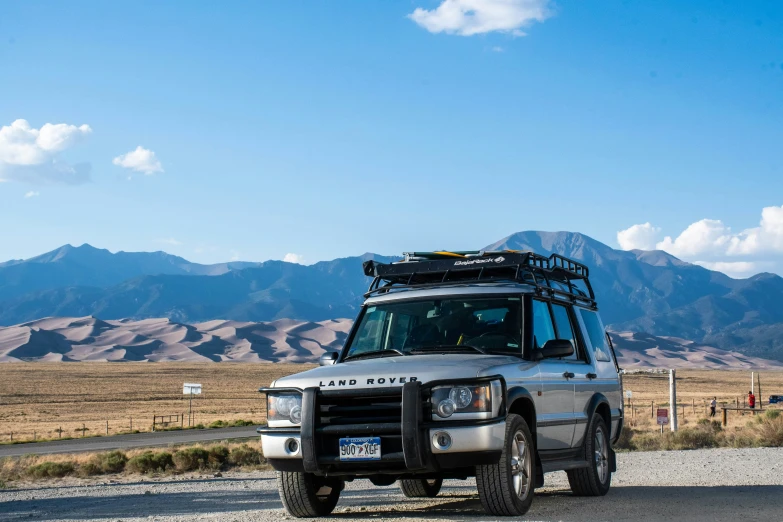 a white and black car parked on a road with mountains in the background