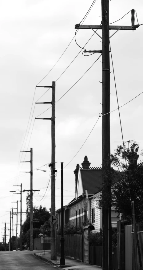 an empty road lined with telephone poles on either side of buildings