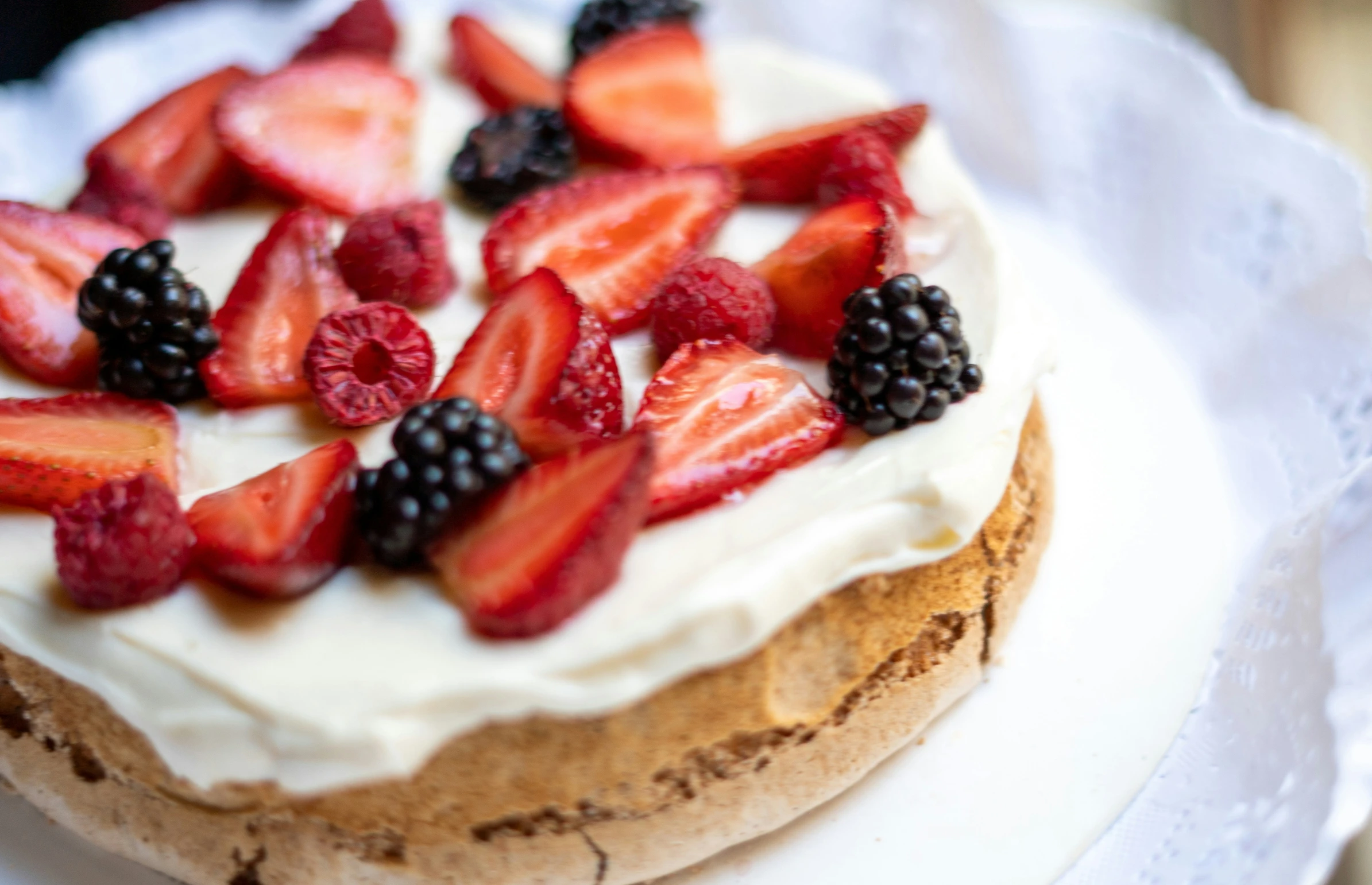 a cake is topped with whipped cream and berries