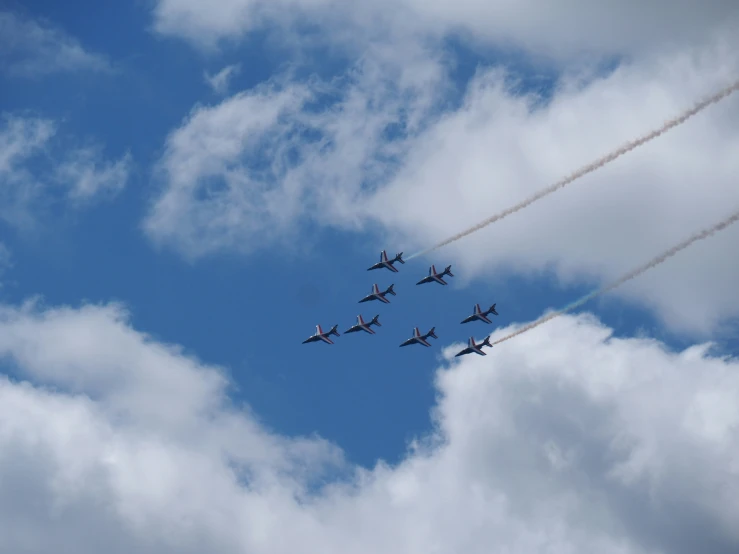 a formation of airplanes flying through the sky