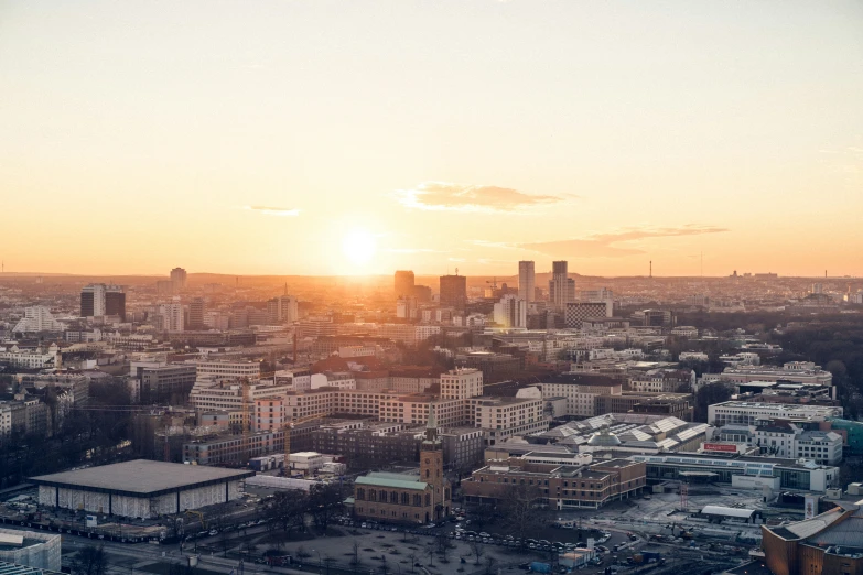 the sun sets over a city with tall buildings