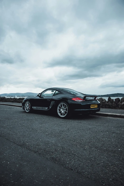 a black car sitting in front of some rocks