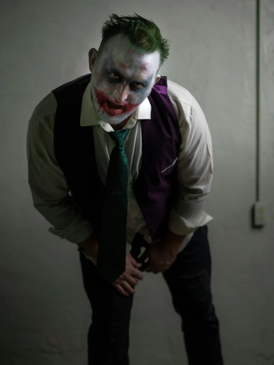 a man dressed as the joker holds his hands on his hips