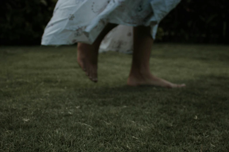 person's feet and dress, standing in grass