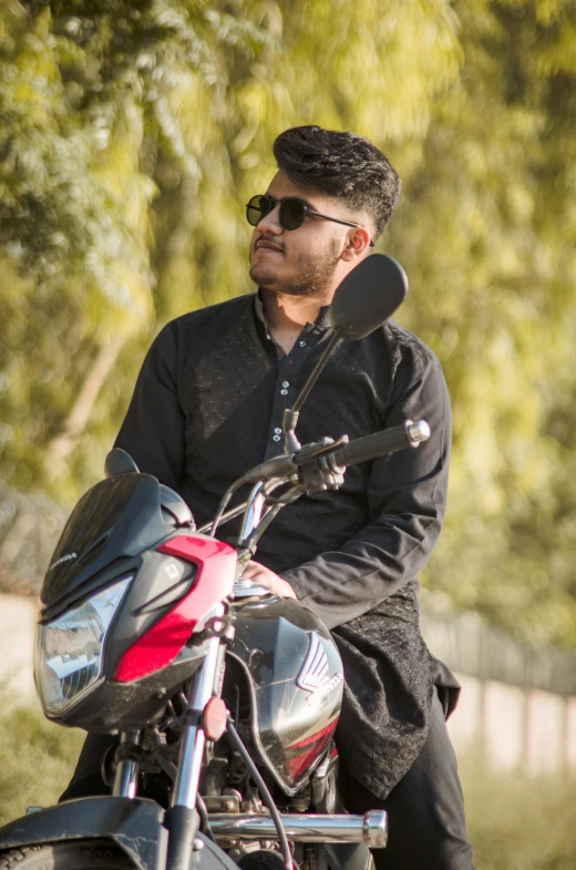 a man sitting on a motorcycle in the sun