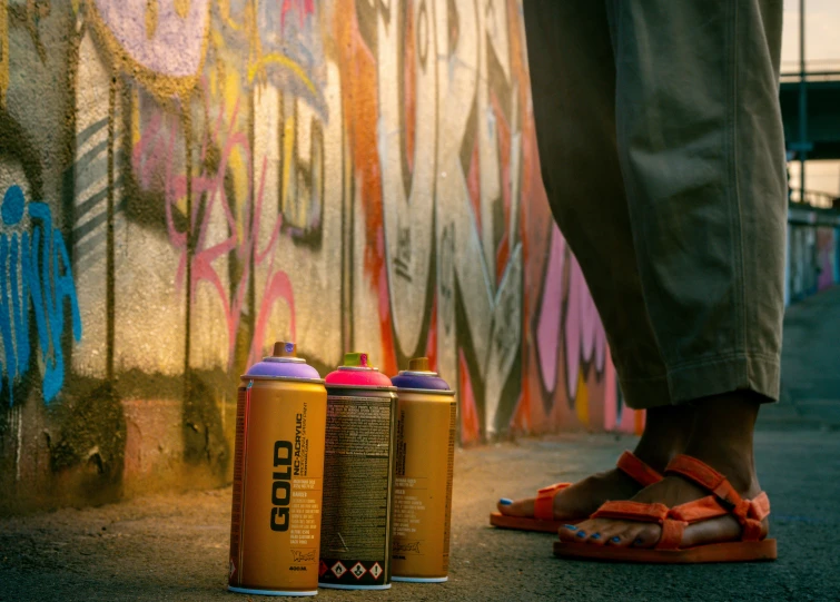 a person is standing next to two can of soda