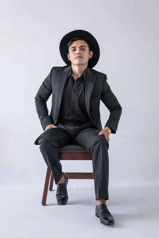 man in hat sitting on chair looking straight ahead