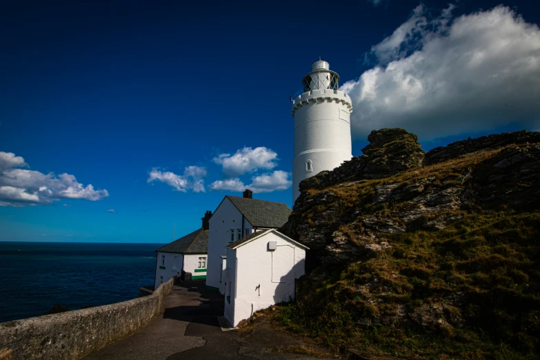 a house near the ocean next to a lighthouse