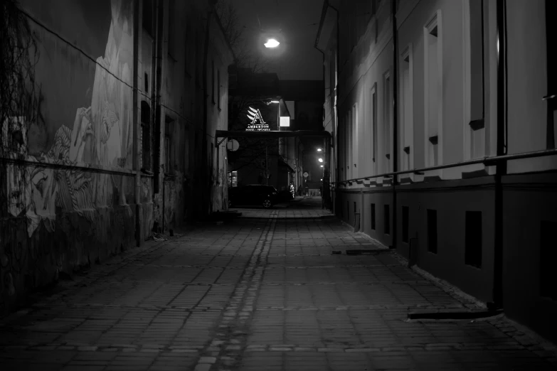 a dark street with a light hanging off the side of it