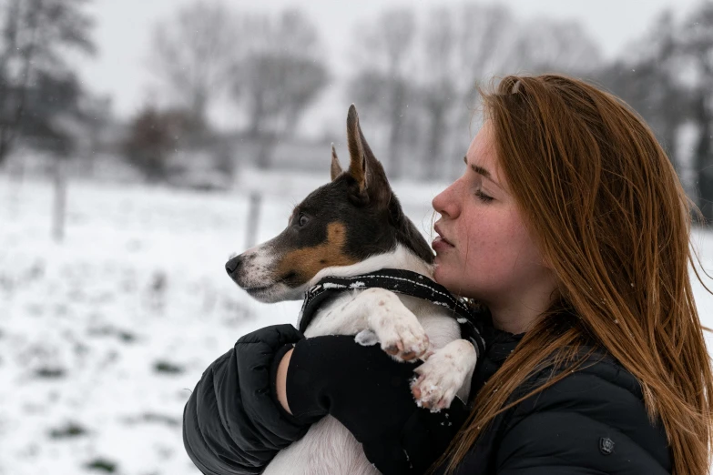 a woman holding a dog in her arms