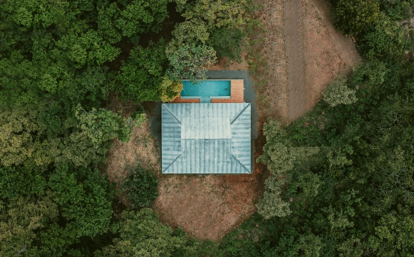 a pool sits in between some trees near a path